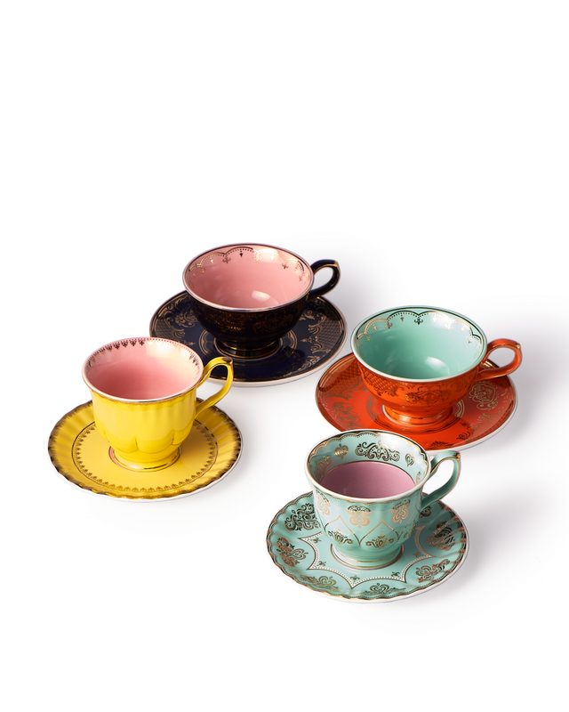 Set of colorful teacups and saucers on a white background